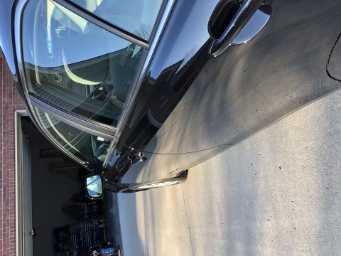 2011 Toyota Camry - A black sedan is parked in a garage, with its side profile clearly visible.