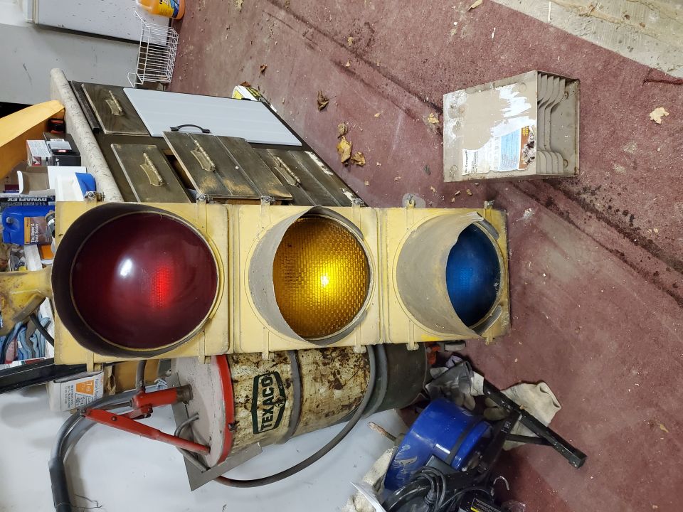 Vintage Texaco-marked traffic signal light standing in a basement