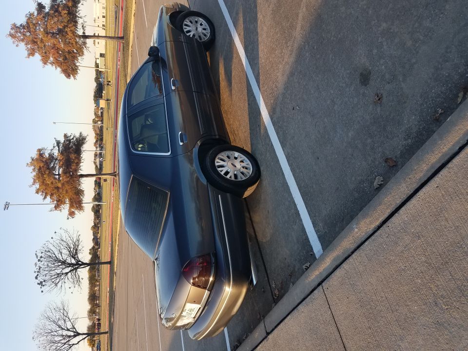 Dark gray 2004 Ford Crown Victoria sedan parked at an angle.