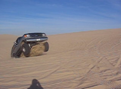 1989 Ford Bronco - Bronco kicking up sand while climbing a dune.