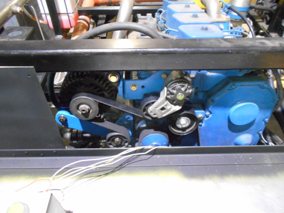 Blue engine with serpentine belt, alternator, and visible hoses and wires.