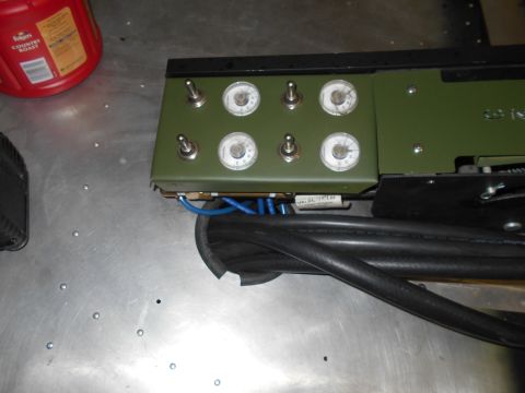 1992 Ford Bronco - A close-up view of a control panel with toggle switches and gauges, connected to thick black cables. A red Folgers coffee container is visi…