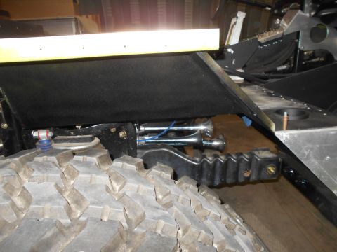 1992 Ford Bronco - A close-up view shows the suspension and undercarriage of a vehicle, with a large tire in the foreground and air horns mounted above it.