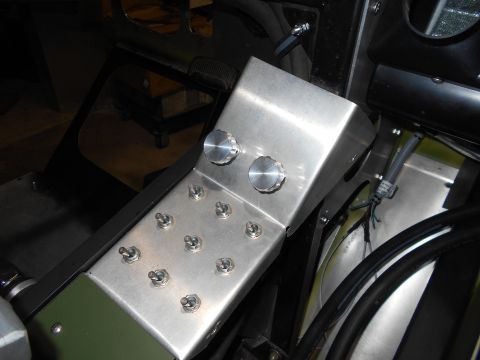 1992 Ford Bronco - A custom metal console with multiple toggle switches and two rotary knobs is installed in the interior of a vehicle. The console is mounted…