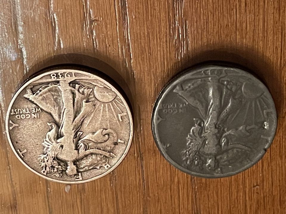 Two Walking Liberty Half Dollar coins on a wooden surface.