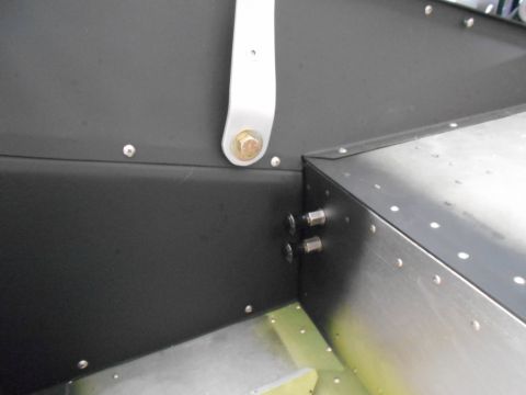 1992 Ford Bronco - A close-up view shows the interior corner of a vehicle's metal body, featuring black panels secured with rivets and bolts. A silver bracket…