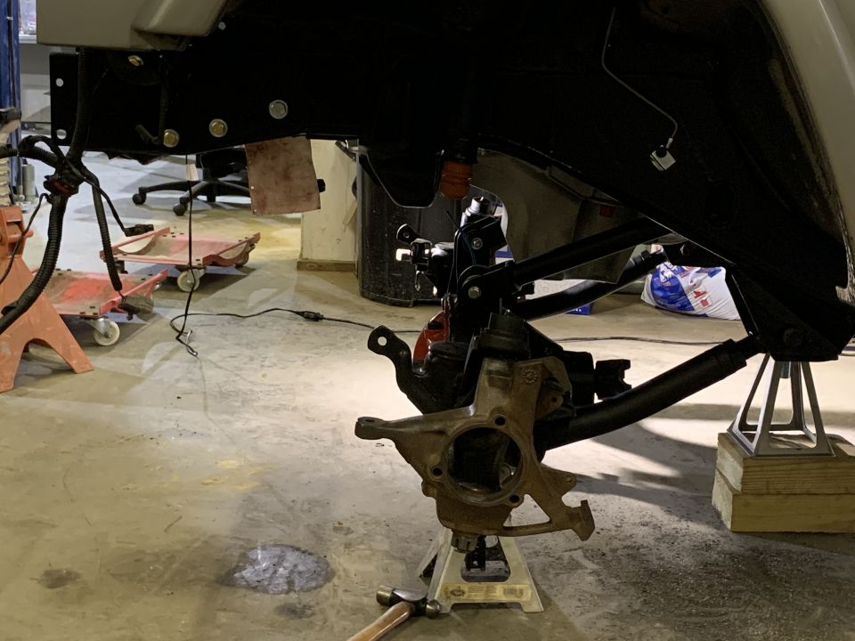Front suspension assembly on jack stands, looks like work is being done on it
