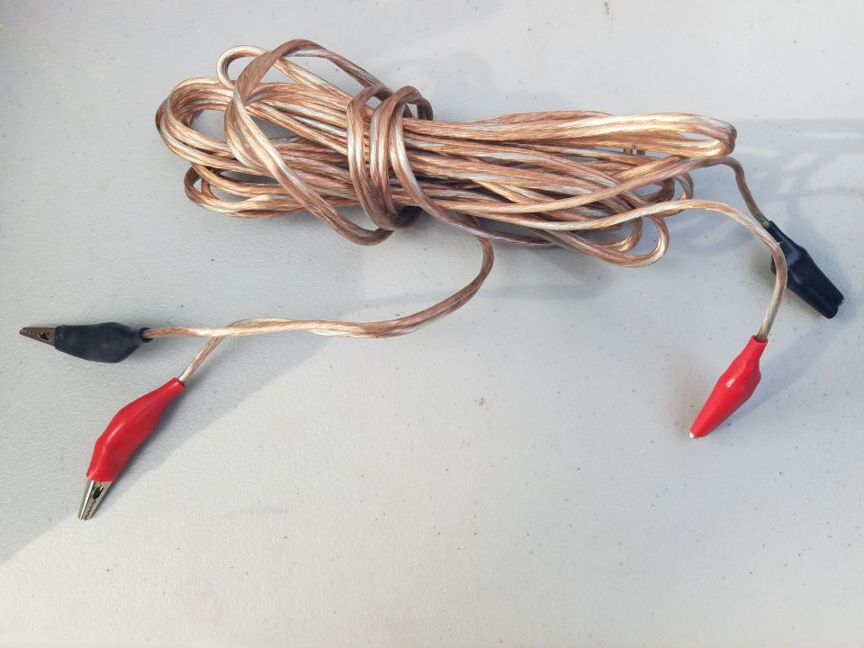 Tangled jumper cables with red and black alligator clips