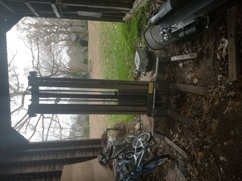 Forklift inside a shed with bicycles and outdoor scene visible through opening