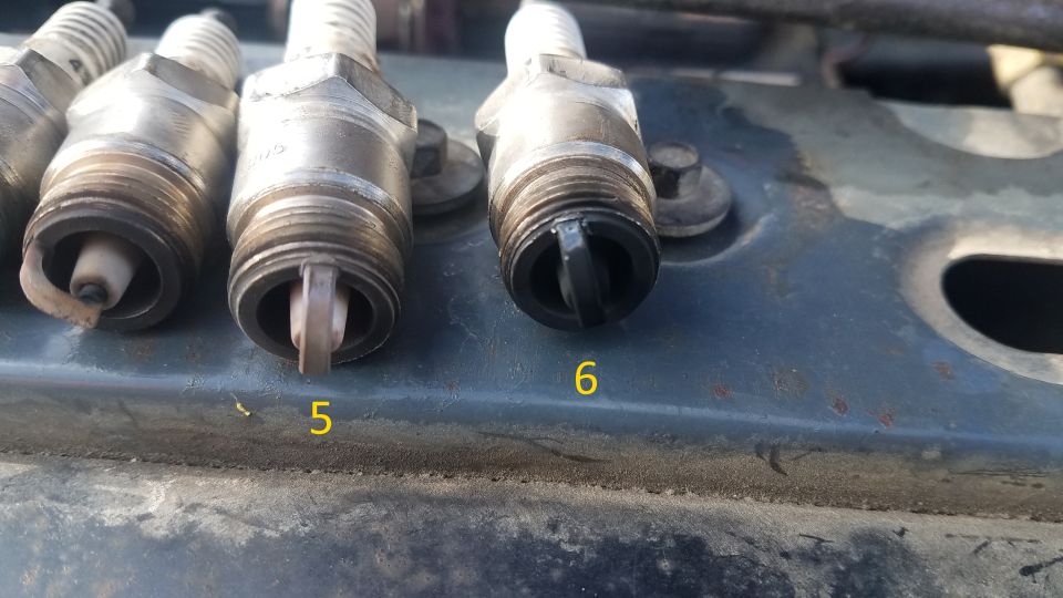 Close-up of four spark plugs, two in focus, labeled 5 and 6