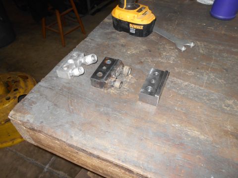 1992 Ford Bronco - Metal hydraulic fittings and a power drill are laid out on a workbench.