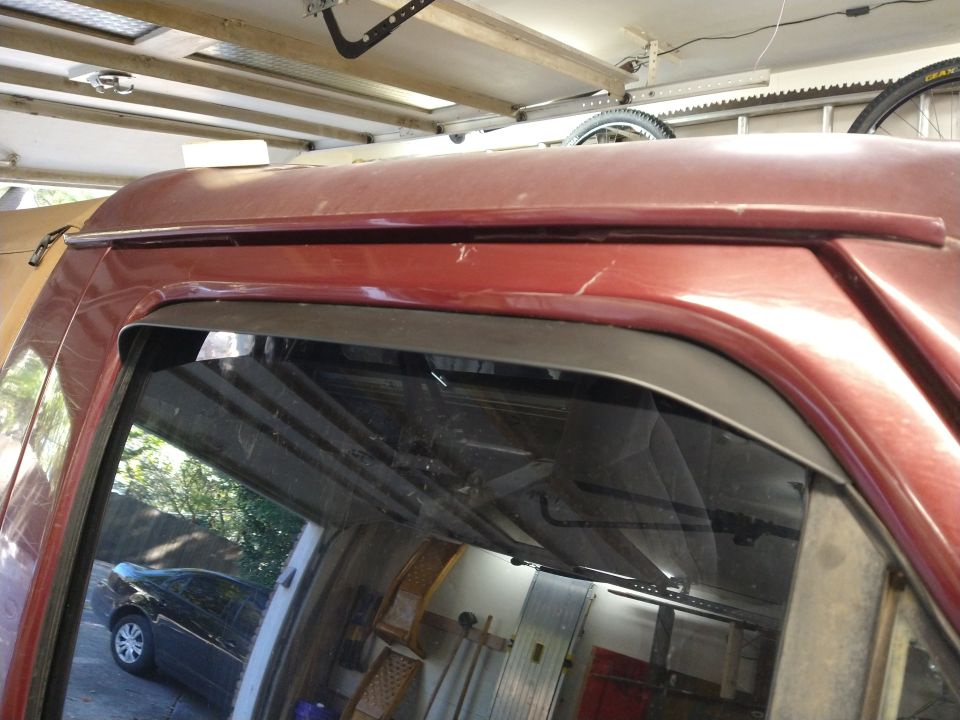 Red SUV roofline and window with in-channel rain guard