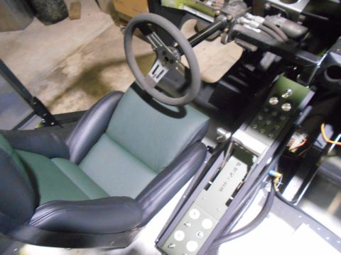 1992 Ford Bronco - Interior view of a vehicle custom bucket seats and a modified center console with numerous buttons.
