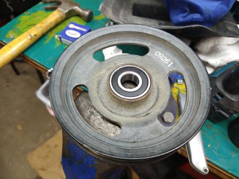 1996 Ford Bronco - A close-up view shows a metal pulley with a bearing and the number "09261" stamped on its surface. The pulley is clamped in a vise on a wor…