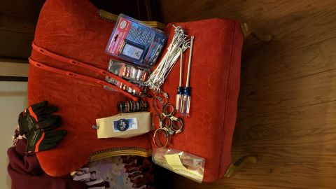 1965 Ford Mustang - Various tools and automotive parts are laid out on a red upholstered chair.