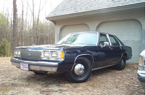 1991 Ford LTD Crown Victoria - This Ford sedan has a distinct grille and headlight design, indicative of an earlier model year.