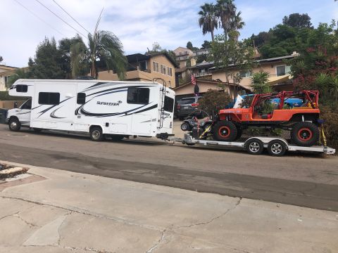 1992 Jeep Wrangler - RV towing a trailer with an orange Jeep Wrangler and an ATV on it.