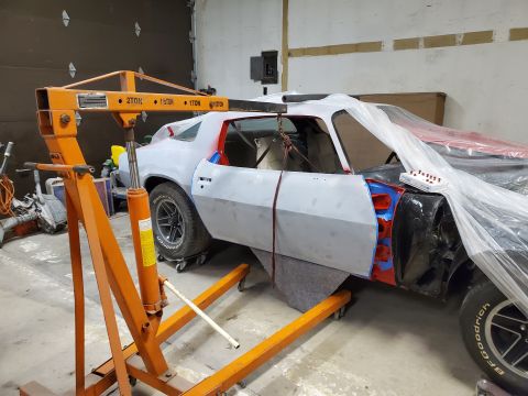 1979 Chevrolet Camaro - A 1979 Chevrolet Camaro is being worked on in a garage, with an engine hoist positioned over it.