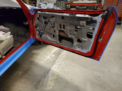 1979 Chevrolet Camaro - The interior of a 1979 Chevrolet Camaro's red door is shown with its internal mechanisms exposed during a restoration.