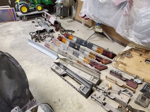 1979 Chevrolet Camaro - Various automotive parts are organized on a workshop floor, suggesting a restoration or repair project.