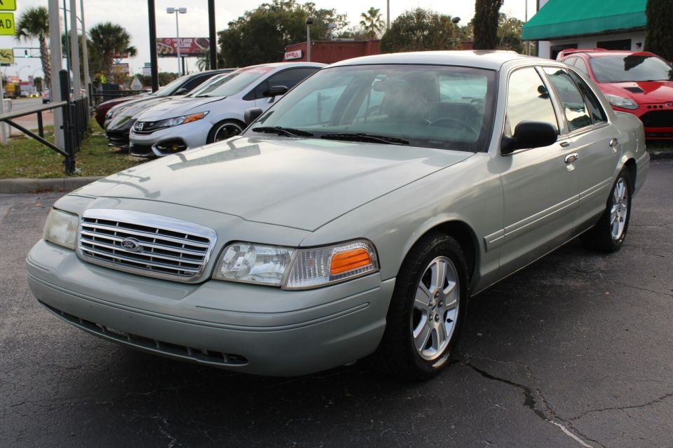 Silver sedan parked in lot, other cars behind it. Watermark at bottom right
