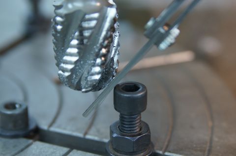 1979 Ford Bronco - A close-up shows a milling cutter bit and a metal rod being measured with calipers.