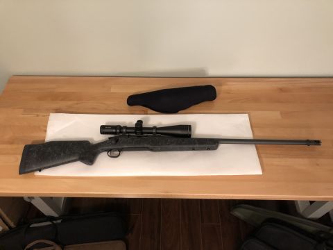 1995 Mercury Grand Marquis - A rifle with a scope is placed on a table, accompanied by a black protective cover.