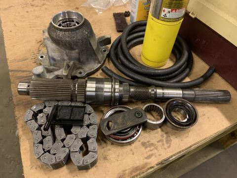 2000 Jeep Cherokee - Various parts of a vehicle's transfer case are arranged on a workbench, ready for assembly or repair.