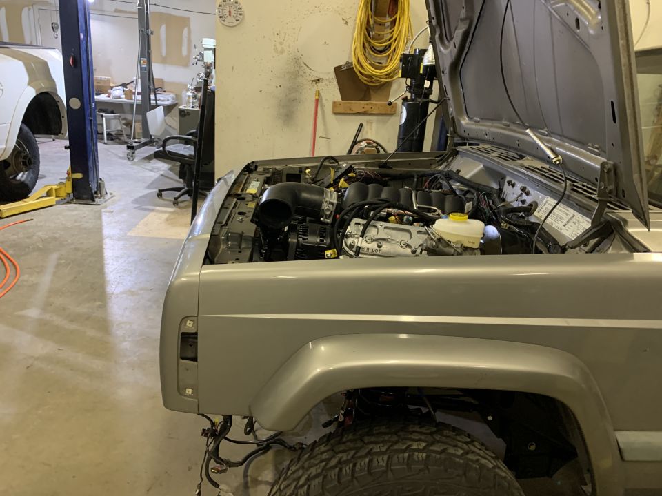 2000 Jeep Cherokee engine bay with hood open, showing engine components and wiring