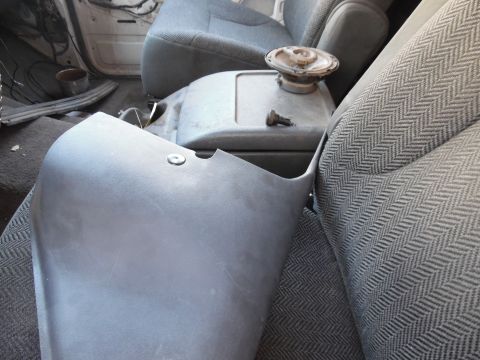 1992 Ford Bronco - Interior view of a vehicle's front seats and center console, showing a speaker and a detached plastic panel.