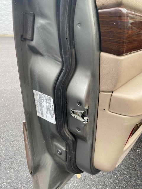 1995 Mercury Grand Marquis - Close-up of a car's door jamb, revealing the latch and a compliance sticker.