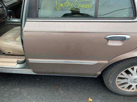 1995 Mercury Grand Marquis - The side of a tan Mercury Grand Marquis shows its interior and a handwritten message on the rear window.