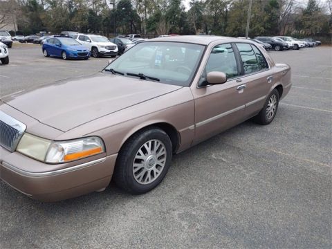 1995 Mercury Grand Marquis - This Mercury Grand Marquis sedan is a tan color and is parked in an outdoor lot.
