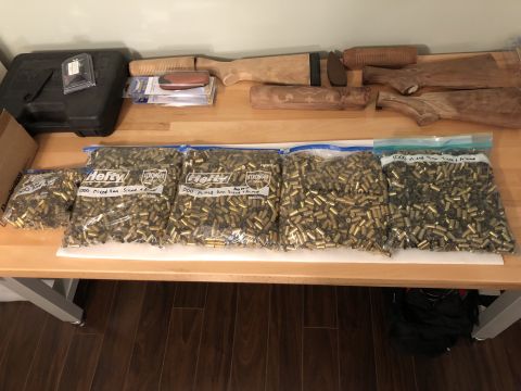 1995 Mercury Grand Marquis - Several bags of ammunition and unfinished wooden gun stocks are laid out on a table.