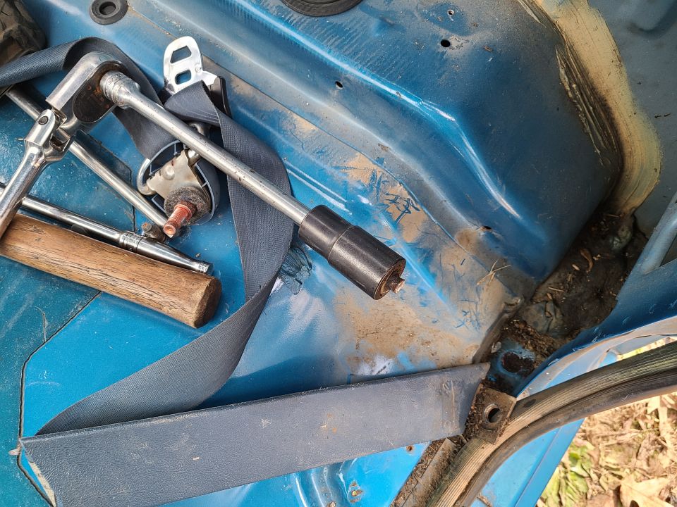 This seat belt bolt was also seized, but its head came off. I haven't attempted to extract the rest of the bolt from the body.

UPDATE: I got it out without damaging the cab.
