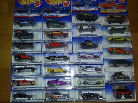1989 Ford F-350 - Numerous Hot Wheels toy cars are displayed in their original packaging, covering a table surface.