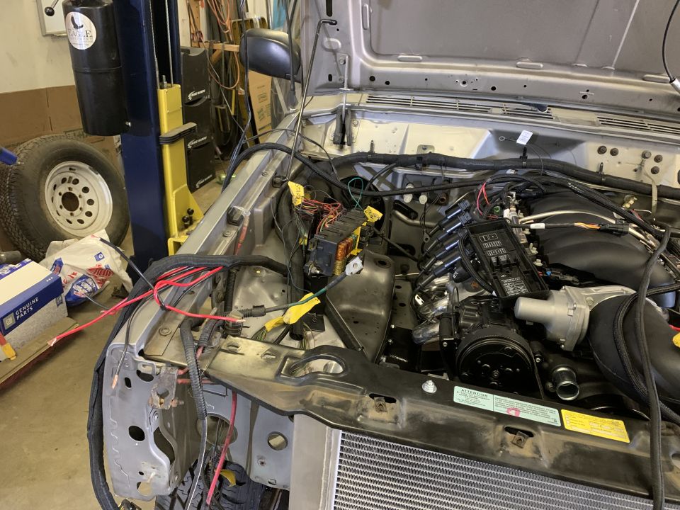 Engine bay of a Jeep Cherokee with a custom engine swap, showing wiring and engine components