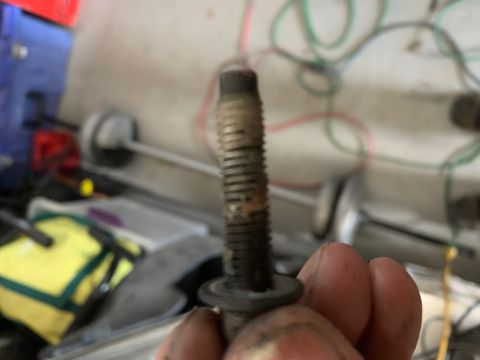 1996 Ford Bronco - Close-up of a bolt with visible threads and a washer, held by fingers.