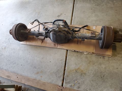 1996 Ford Bronco - Rear axle assembly with drum brakes and brake lines, likely from a truck or SUV.