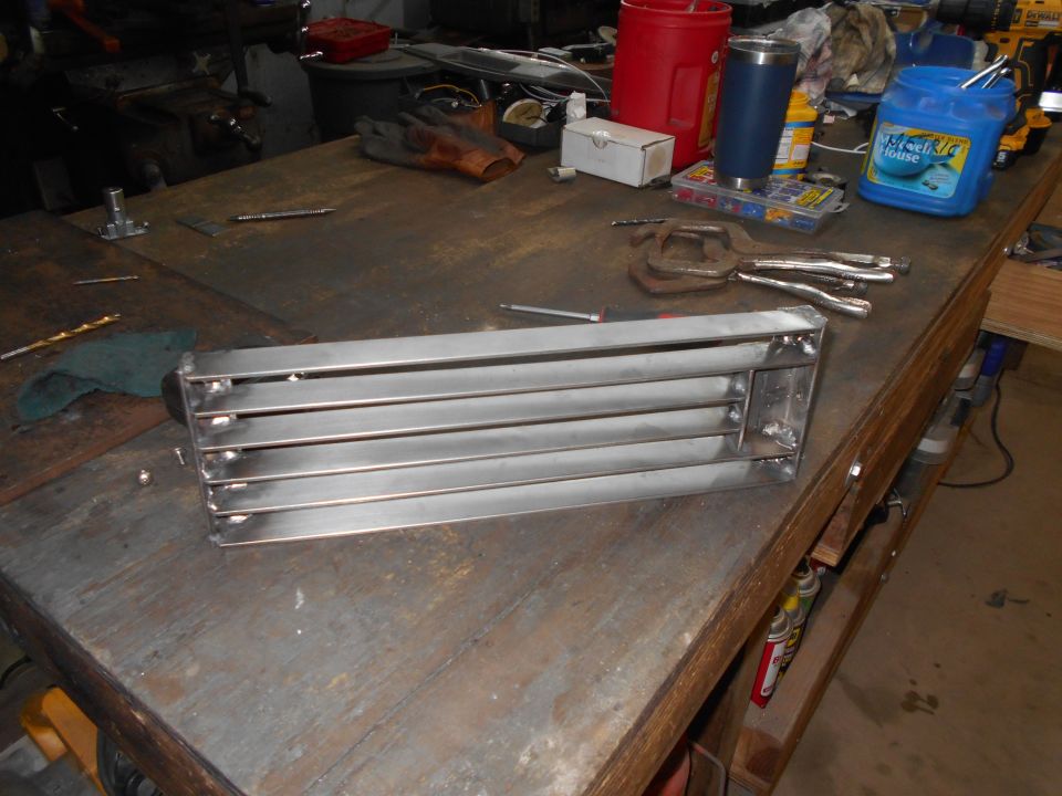 Metal grille with horizontal slats on a workbench with tools