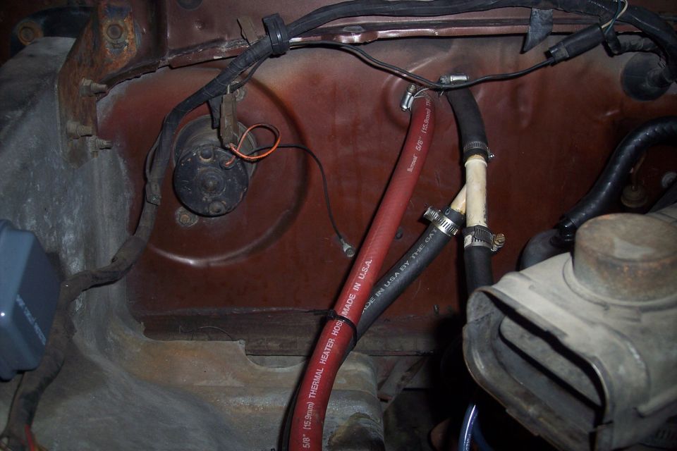 Close-up of heater hoses and blower motor assembly in a vehicle