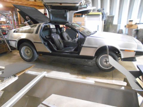 1992 Ford Bronco - This DeLorean DMC-12 is in a garage, its iconic gullwing doors are raised.