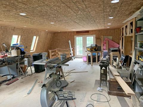 1992 Jeep Wrangler - A busy workshop is filled with various woodworking tools and materials, suggesting ongoing construction or projects.