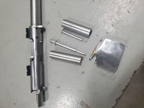 1996 Ford Bronco - Disassembled firearm components are laid out on a workshop floor, with a website watermark in the corner.