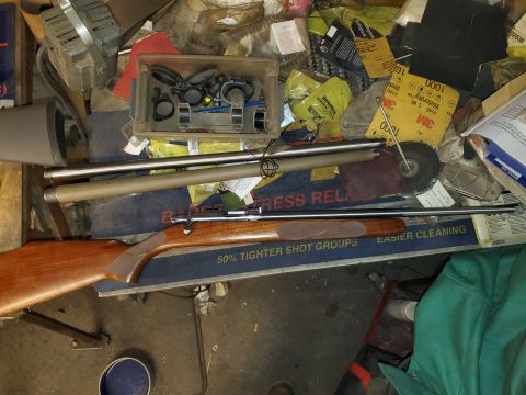 1996 Ford Bronco - Rifle and gun scope parts are scattered amongst various tools and supplies in a workshop.