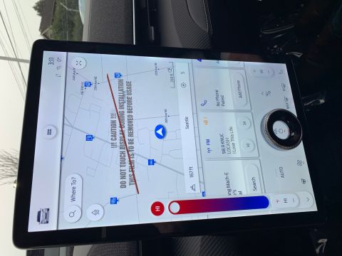 2021 Ford Mustang - The vehicle's navigation screen displays a map and climate controls, with a prominent warning about a protective film.