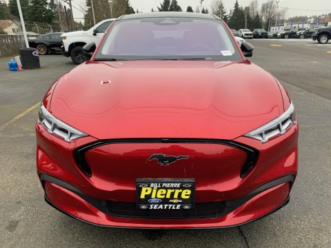 2021 Ford Mustang - The front of a red Ford Mustang Mach-E is shown, its distinctive horse emblem and modern headlights.