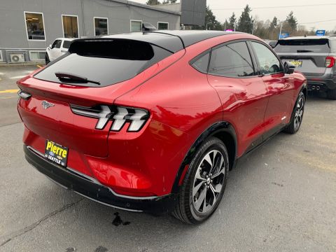 2021 Ford Mustang - Red Ford Mustang Mach-E with a black roof and wheels is viewed from the rear quarter angle.