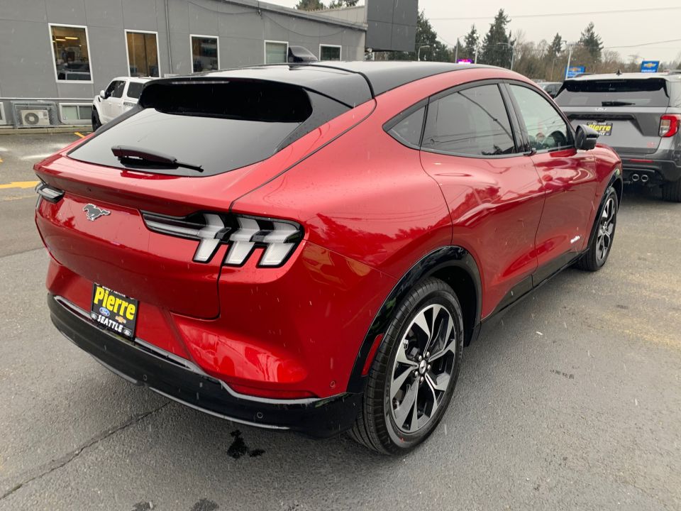 Red Ford Mustang Mach-E rear quarter view, black roof, black wheels, license plate frame reads Pierre Seattle