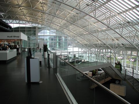 2010 Audi A4 - View of a modern Audi dealership interior, showing cars on display and architectural details.
